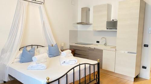 a bedroom with a bed with blue pillows and a kitchen at B&B La Loggia Del Castello in Trento
