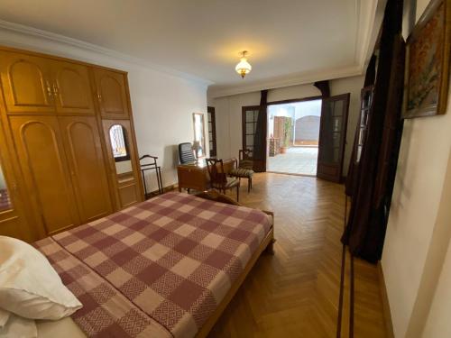 a bedroom with a bed with a checkered blanket at Villa Maadi 35 -R 2- Poolside Queen Room in Cairo