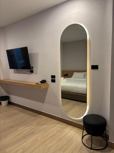 a room with a mirror and a bed and a chair at PACINN Narathiwat โรงแรมพักอินน์ นราธิวาส in Kampong Botong