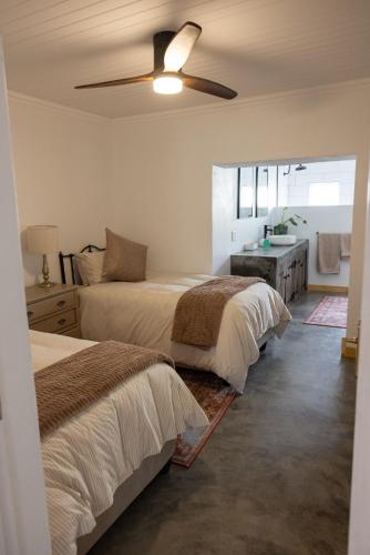 a bedroom with two beds and a ceiling fan at Casa Del Sol Cottage in McGregor