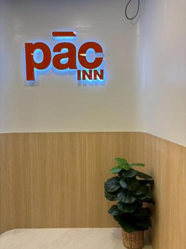 a pago inc sign on a wall with a plant at PACINN Narathiwat โรงแรมพักอินน์ นราธิวาส in Kampong Botong