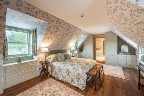 ein Schlafzimmer mit einem Bett und einem Fenster in der Unterkunft Grieves Cottage Balnagown Estate in Kildary