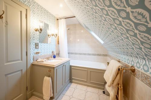 ein Badezimmer mit Waschbecken und Badewanne in der Unterkunft Grieves Cottage Balnagown Estate in Kildary