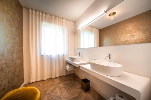 a bathroom with two sinks and a mirror at goldfinger + suites in Lana