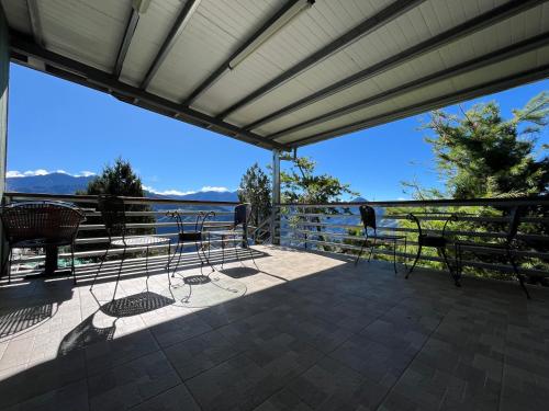 a patio with chairs and a view of the water at Hua Mu Xing Jing B&B in Renai