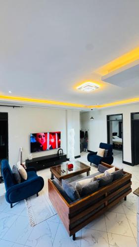 a living room with couches and a flat screen tv at Ikamba Homes-Munyonyo in Kampala