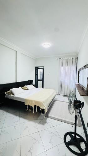 a bedroom with a bed in a room with a fan at Ikamba Homes-Munyonyo in Kampala