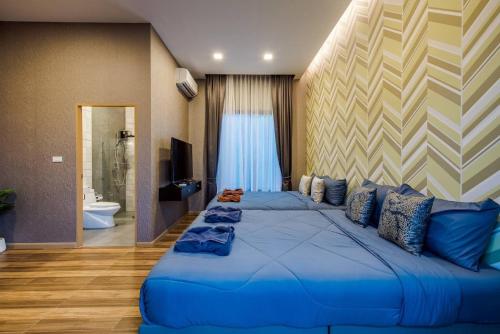 a large blue bed in a room with a bathroom at Sky Blue Pool Villa at Hua Hin 3Bedrooms and 4 Bathrooms near Cha-Am beach in Nikhom Sang Ton Eng Khuan Phet