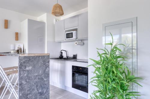 a kitchen with white cabinets and a plant at Seaside View 406 in Saint-Laurent-du-Var