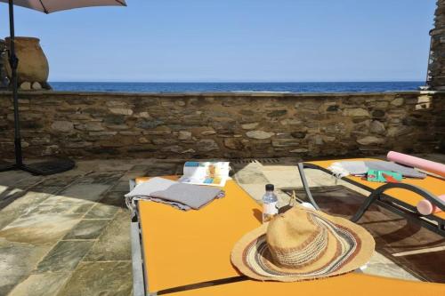 a straw hat sitting on a table with the ocean in the background at Casa Torra d'Erbalunga in Brando