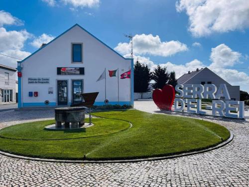 a white building with a sign in front of it at Marazul in Serra de El-Rei