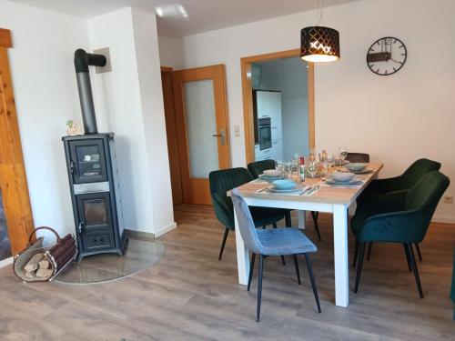 a dining room with a table and a wood stove at Savor Appartement Bergblick für 6 Personen in Sohland