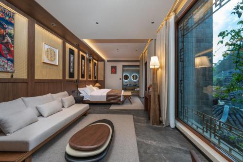 a living room with a couch and a bed at YiQuan RIVERVIEW B&B in Fenghuang
