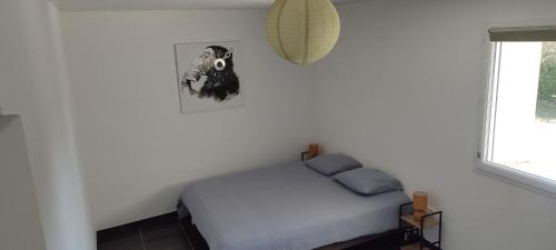 a white bedroom with a bed and a window at Le Petit Clazayéen in Bressuire