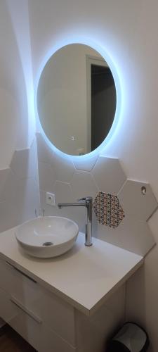 a bathroom with a white sink and a mirror at Le Petit Clazayéen in Bressuire