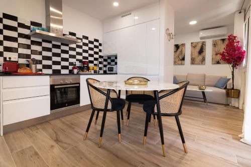 Una cocina con una mesa y sillas en una habitación. en Charming Seaside Apartment in Barceloneta, Renovated with Stunning Sea Views, en Barcelona