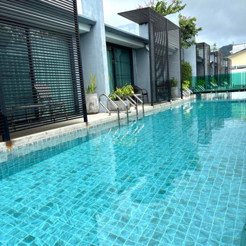 a swimming pool with chairs next to a building at Xen Pool Access in Chalong 