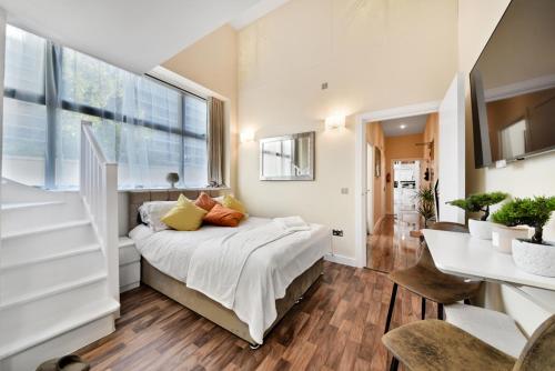 a bedroom with a bed and a desk and a window at London Lets Stay Here with parking in Ilford