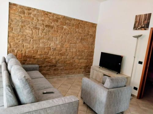a living room with a couch and a chair and a tv at CASA CENTRO STORICO VOLTERRA in Volterra