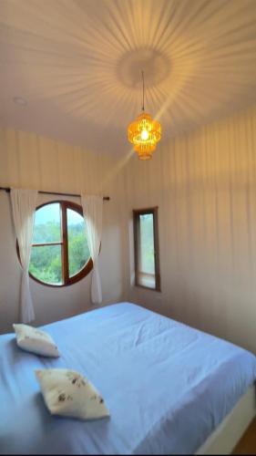 a bedroom with a large bed and a chandelier at ม่อนหมอกเชียงดาว in Chiang Dao