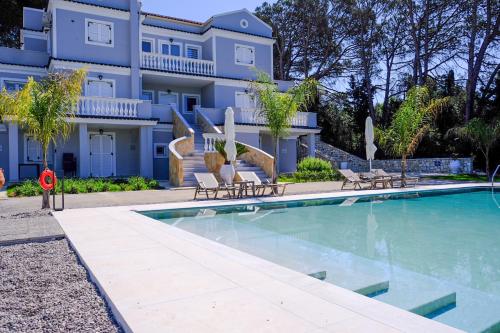 a swimming pool in front of a house at The Seven Islands Deluxe Apartments in Gouvia
