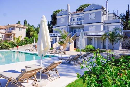 a villa with a swimming pool and lounge chairs at The Seven Islands Deluxe Apartments in Gouvia