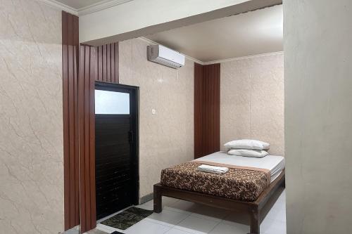 Un dormitorio pequeño con una cama y un espejo. en BB Homestay Two, en Uluwatu