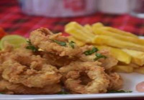 a plate of food with shrimp and french fries at Utulivu Bungalow in Nungwi