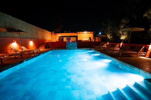 a swimming pool at night with chairs and lights at Villa Marrakchia - Palais d'hôtes & spa in Marrakech