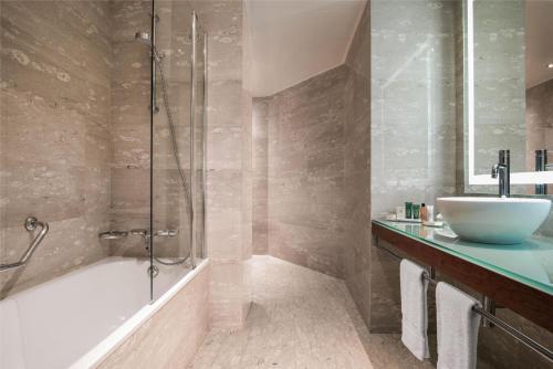 a bathroom with a tub and a sink and a shower at Hilton Diagonal Mar Barcelona in Barcelona