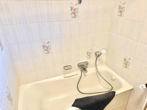 a bathroom with a bath tub with a shower at Haus Schwarzwald - Bad Krozingen in Bad Krozingen