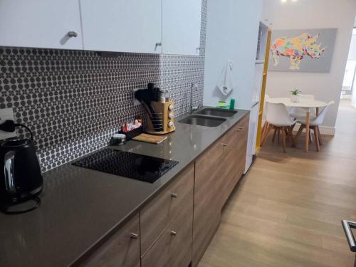 a kitchen with a counter and a sink and a table at iKON Self-Catering in Windhoek