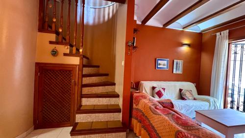 Habitación con escalera, sofá y mesa. en Bahia Azul Denia VyB, en Denia