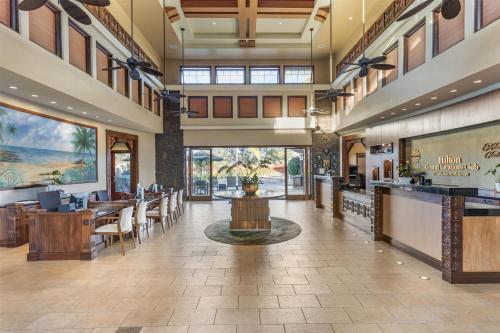 a lobby of a restaurant with tables and chairs at Hilton Grand Vacations Club Kohala Suites Waikoloa in Waikoloa