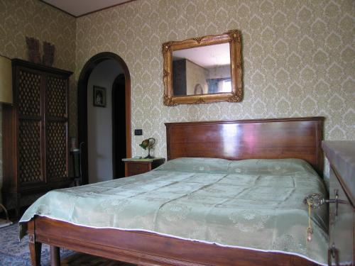 a bedroom with a bed with a mirror on the wall at Villa Tra' Monti in Bassano del Grappa