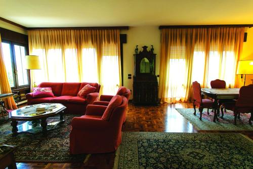 a living room with red couches and a table at Villa Tra' Monti in Bassano del Grappa