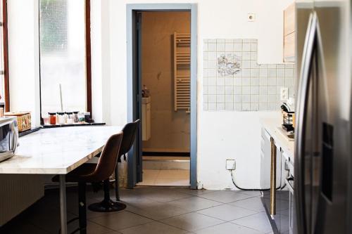 a kitchen with a table and a refrigerator at Spacious villa with garden - ideal for groups in Gerpinnes