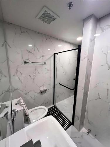 a bathroom with a shower and a toilet and a sink at Davao Condo Bed Space - Safe, Affordable & Comfy in Davao City