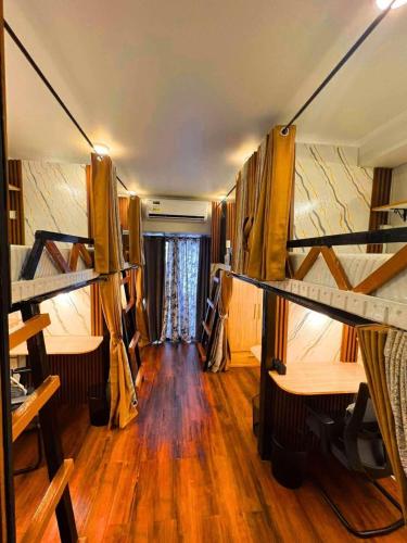 a room with two bunk beds and a wooden floor at Davao Condo Bed Space - Safe, Affordable & Comfy in Davao City