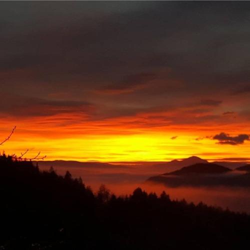 a sunset over a mountain with a layer of clouds at Urlaub am Christofberg in Christofberg