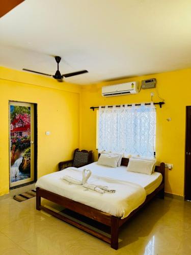a bedroom with a large white bed with a window at Chelsea inn in Calangute