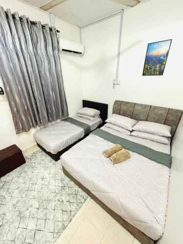 a bedroom with two beds and a window at Effa Homestay in Sungai Petani
