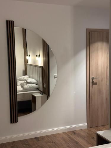 a bedroom with a circular mirror and a bed at Casa David Valea Avrigului in Avrig
