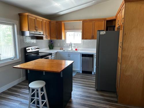 eine Küche mit Holzschränken und einem schwarzen Kühlschrank in der Unterkunft Renovated 2 bdrm apartment in central Hamilton in Hamilton