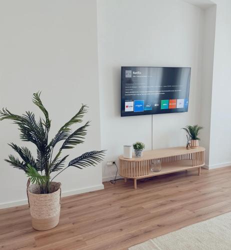 a living room with a flat screen tv on a wall at Suites in Brunn am Gebirge in Brunn am Gebirge