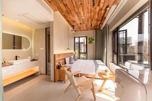 a bedroom with a bed and a tub and a sink at Lu Ming Beiyuan Xi'an Zhongdu Drum Tower City Wall Store in Xi'an