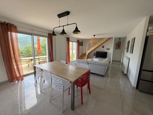 eine Küche und ein Wohnzimmer mit einem Holztisch und Stühlen in der Unterkunft Maison Soulom in Soulom