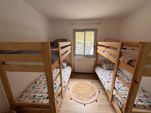 ein Zimmer mit drei Etagenbetten und einem Fenster in der Unterkunft Maison Soulom in Soulom