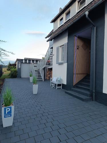 a patio in front of a house with a staircase at Unterkunft mit perfekter Lage zur Küchenwelt in Niederdorla