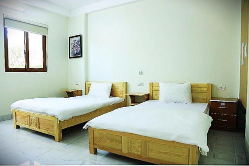 a bedroom with two beds and a window at Than Uyên hotel in Than Uyên
